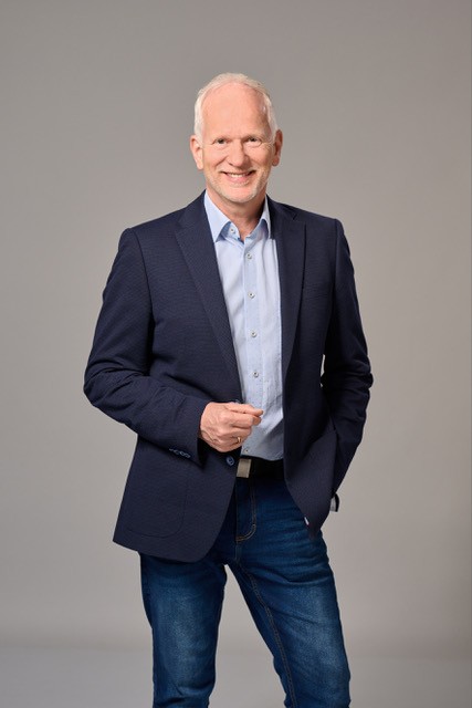 Holger Martin Wilkens im Anzug vor neutralem Hintergrund